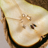 A miniature yellow gold Lemon charm and Pear charm on a yellow gold rolo chain.